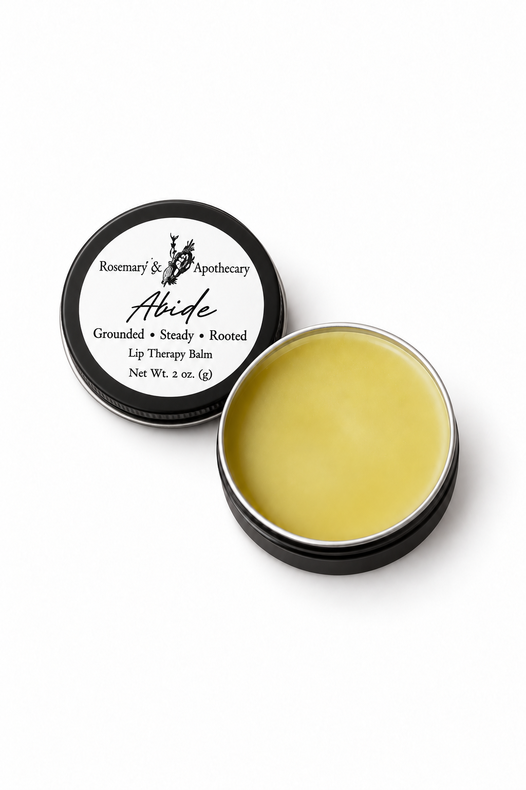 Open tin of Abide herb-infused tallow lip balm showing smooth golden balm beside its labeled black lid on a clean white background.